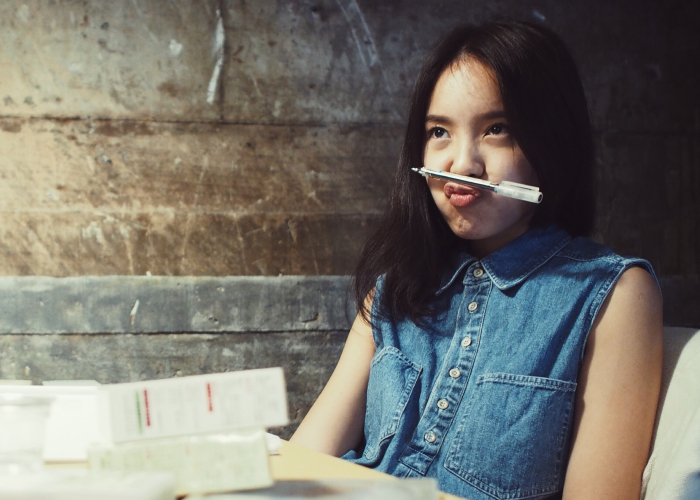 Young girl with pen under her nose